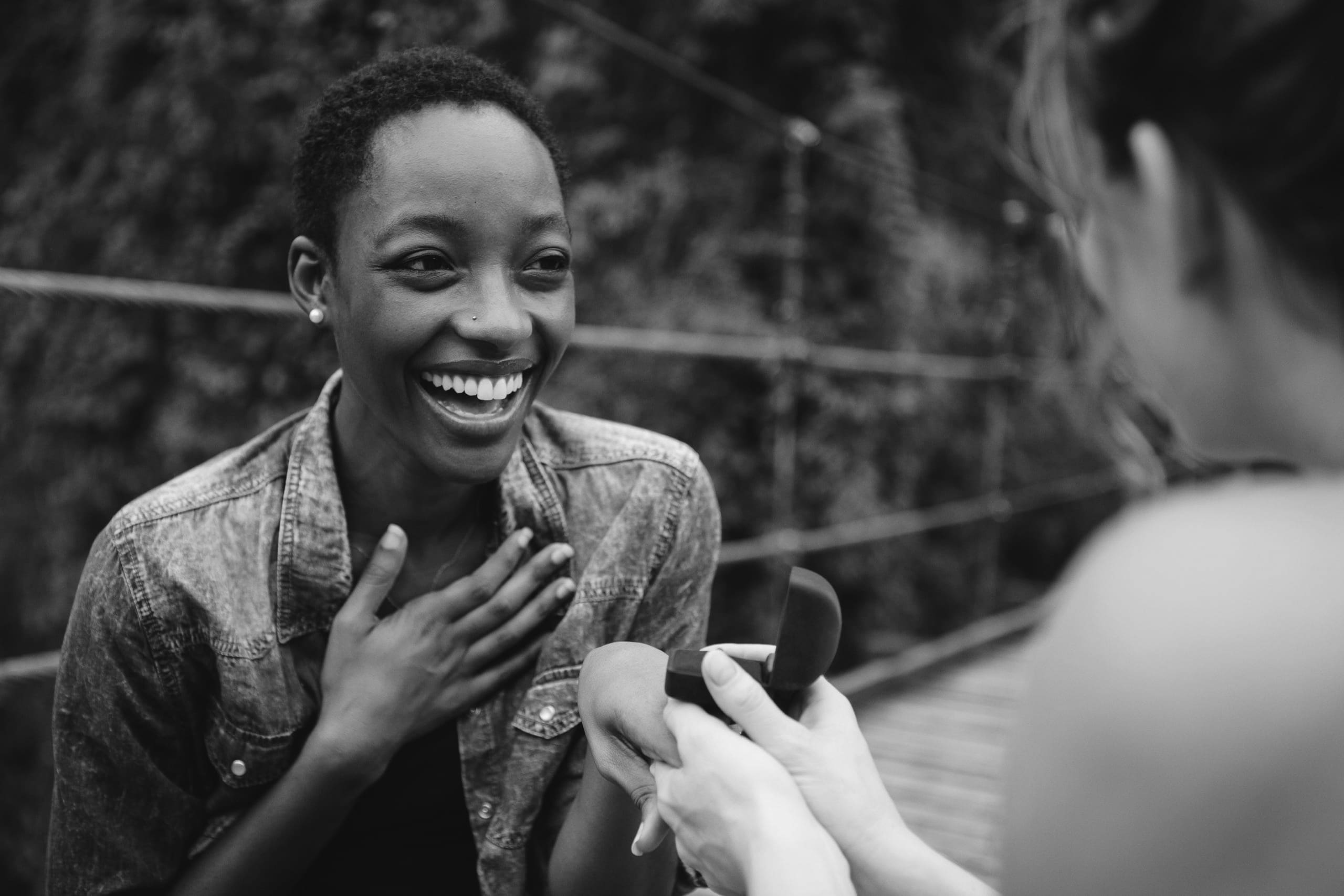 Woman proposing to her happy girlfriend outdoors love and marriage