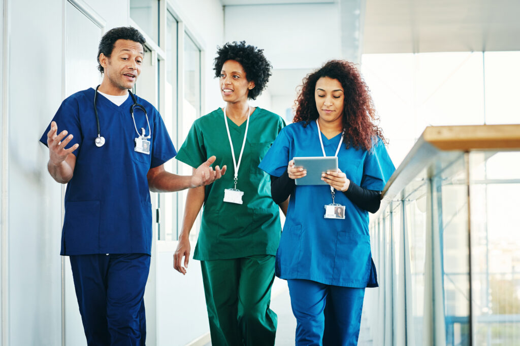 Group of medical professionals discussing along hospital corridor