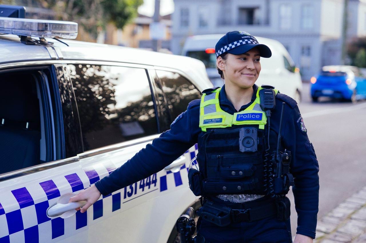 police person opening the police car door.