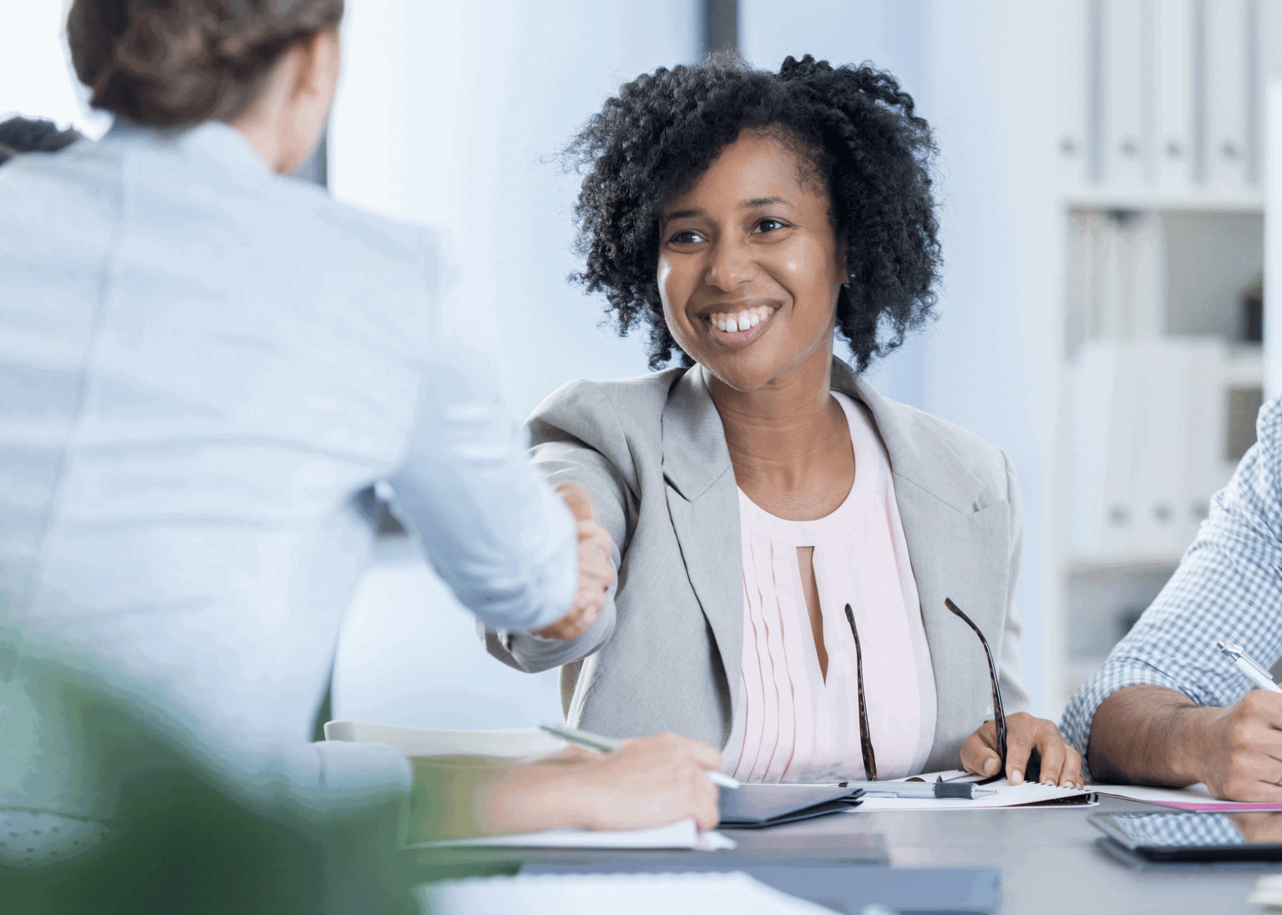 employer shaking hands across the table with employee
