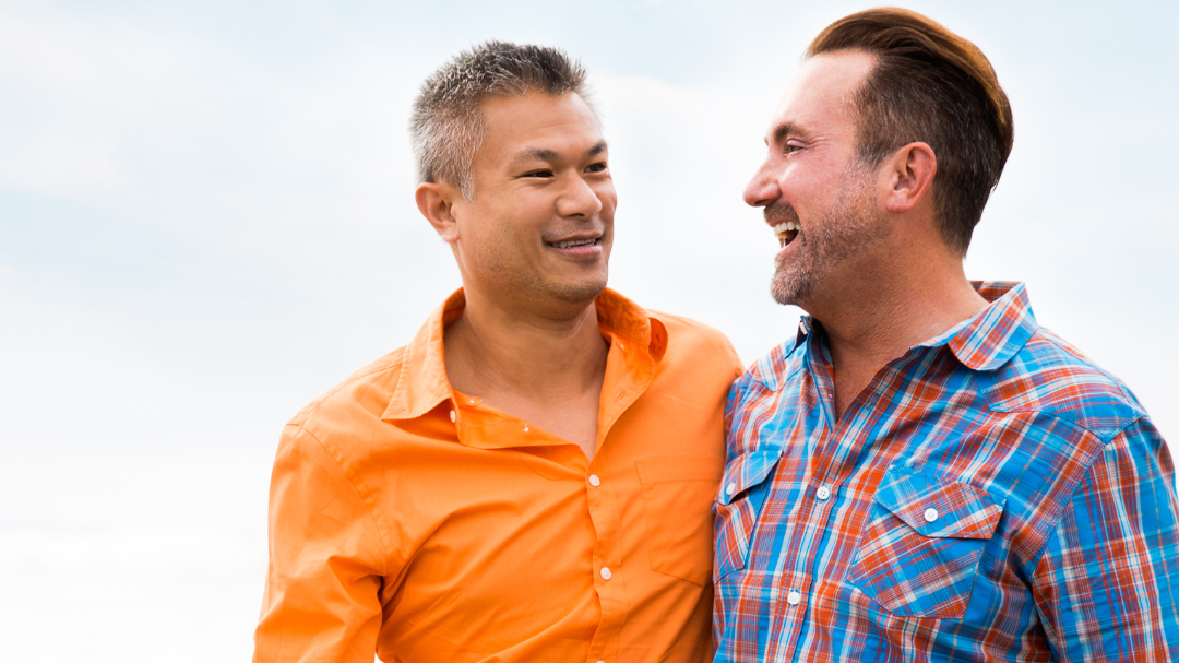 two men in a romantic relationship walking on the beach