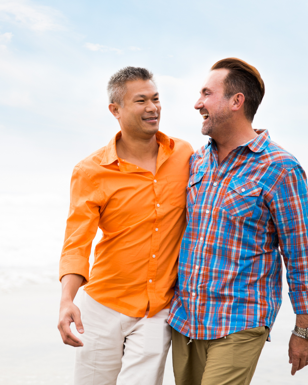 two men in a romantic relationship walking on the beach