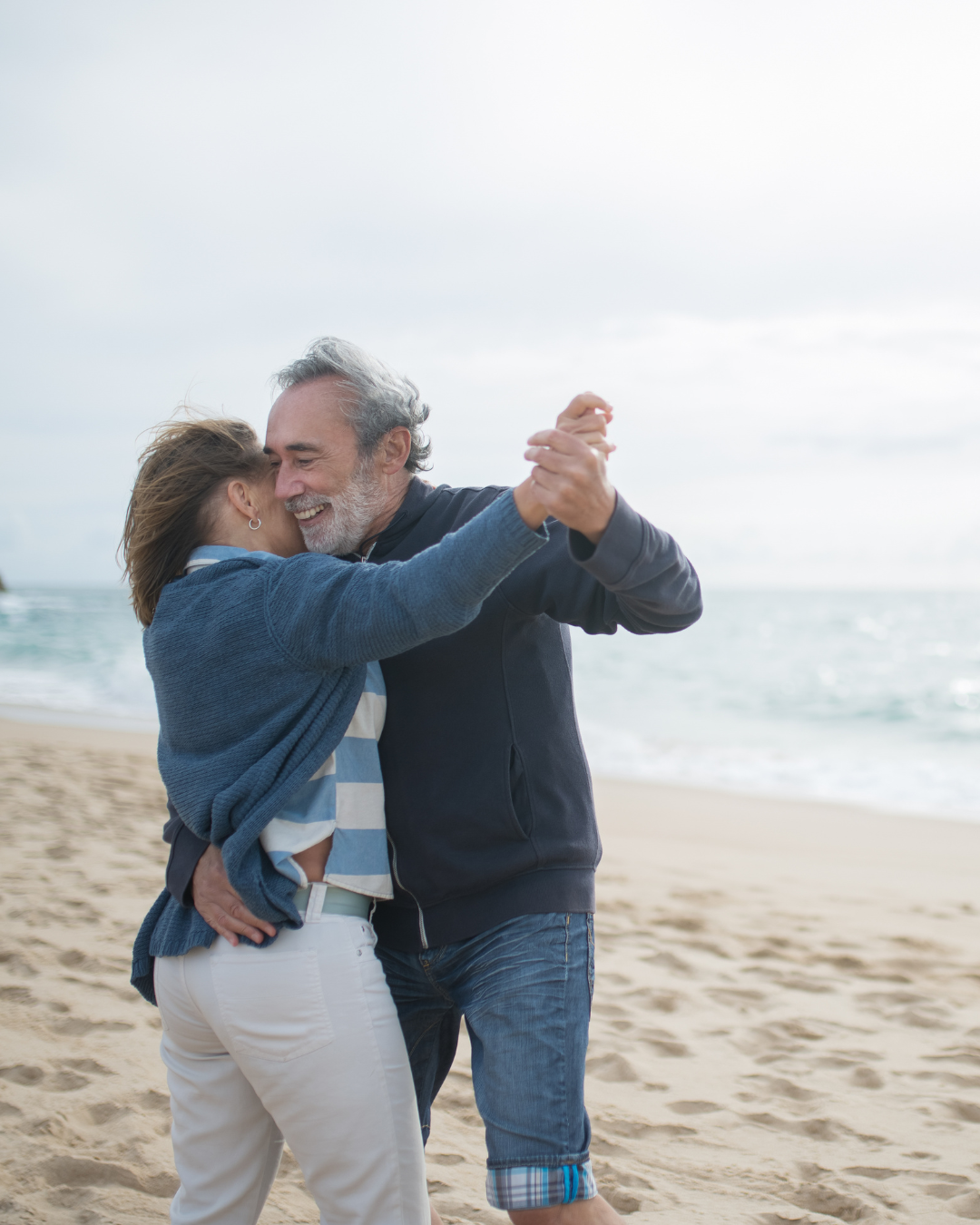 elderly couple dancing on the beach
